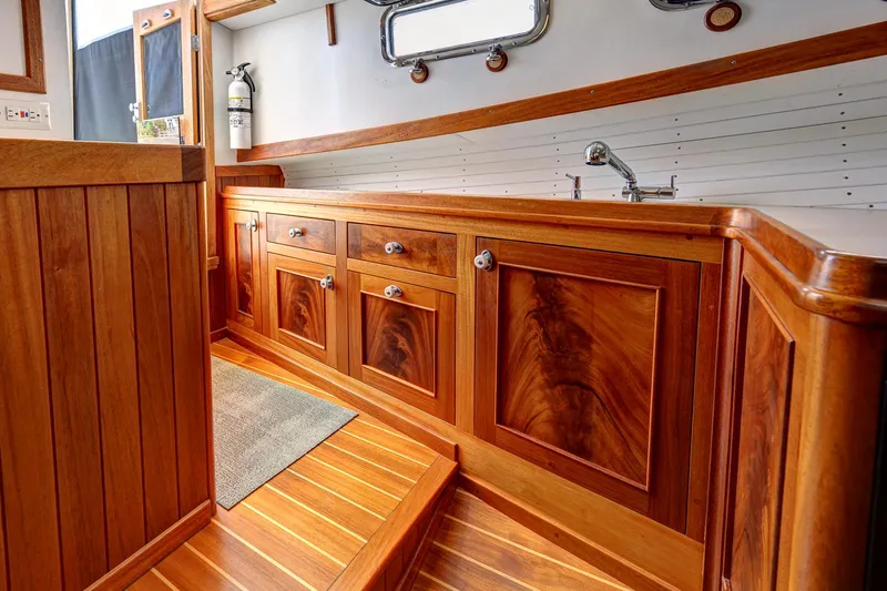 Slide: The Image of Luxurious wooden interior of a 2008 Holland Open boat, featuring elegant cabinetry and flooring. - 18