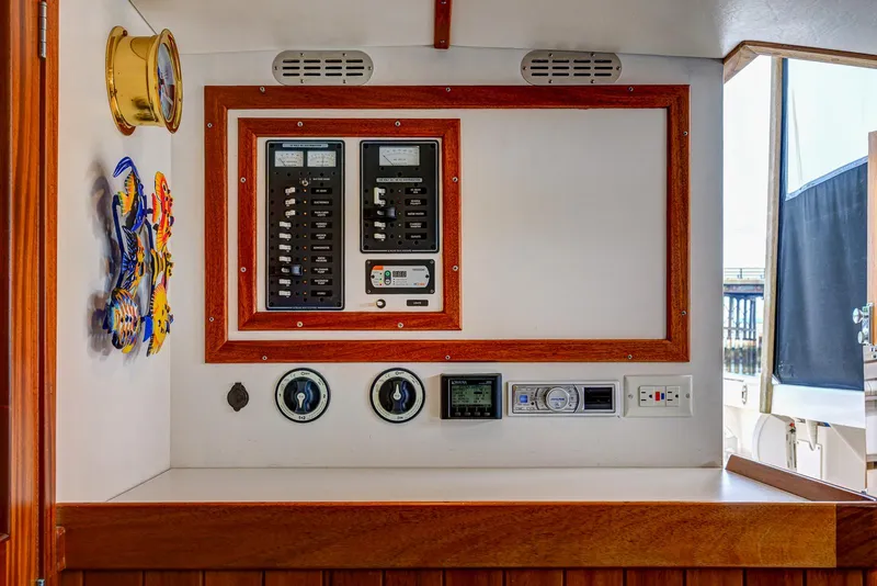 Slide: The Image of Electrical control panel on 2008 Holland Open boat with wooden trim and nautical decor. - 24