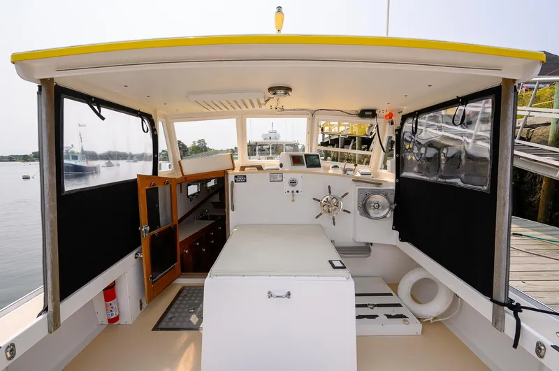 Slide: The Image of 2008 Holland Open boat interior with steering wheel, storage, and dockside view. - 25