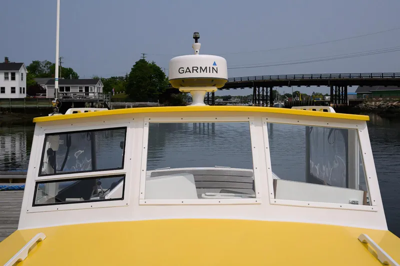 Slide: The Image of Yellow 2008 Holland Open boat with Garmin radar, docked near a bridge and houses. - 34