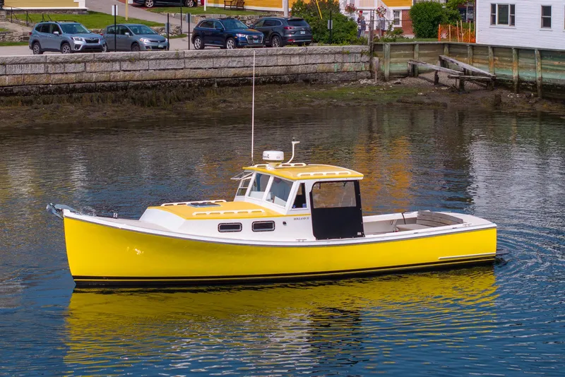 Slide: The Image of Yellow 2008 Holland Open boat docked in calm waters near a coastal town. - 5