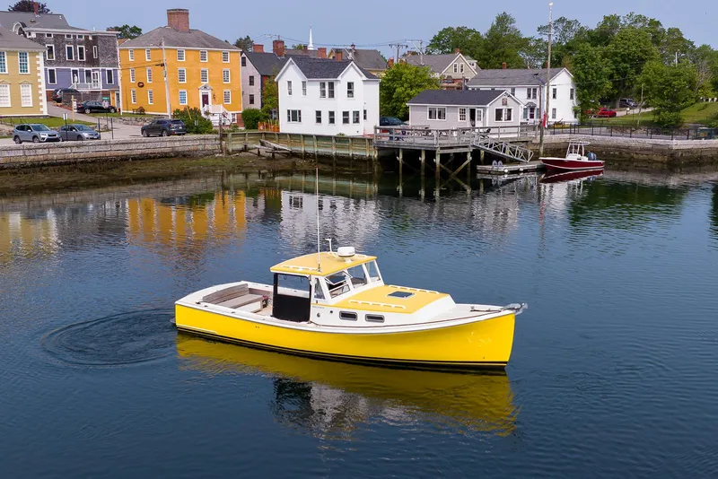 Slide: The Image of Yellow 2008 Holland Open boat on calm water near colorful waterfront buildings. - 9