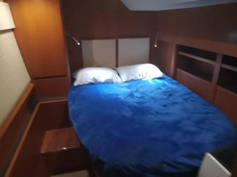 Slide: The Image of Cozy bedroom in 2016 Aquila 44 yacht with blue bedding and wooden interior. - 27
