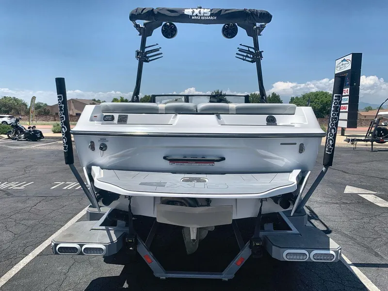 Slide: The Image of 2022 Axis A20 boat, rear view, parked on asphalt under clear blue sky. - 4