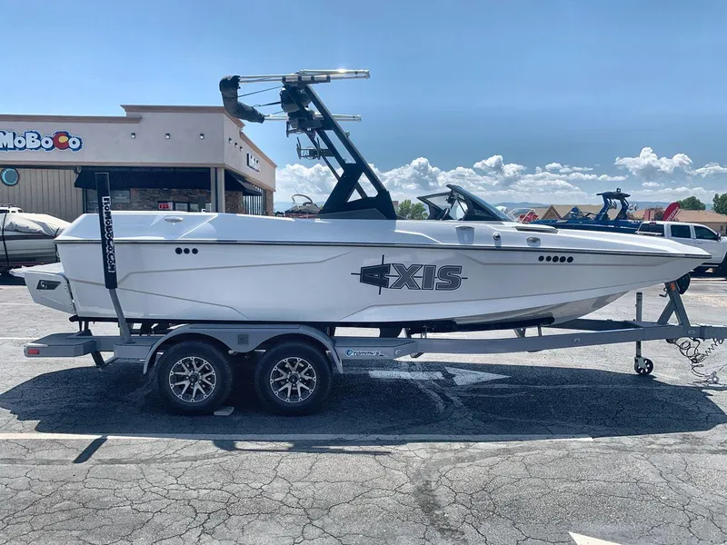 Slide: The Image of 2022 Axis A20 boat on trailer in parking lot, clear sky background. - 6