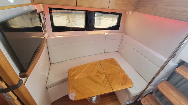 Slide: The Image of Interior of 2021 Boston Whaler 405 Conquest with cozy seating and wooden table. - 15