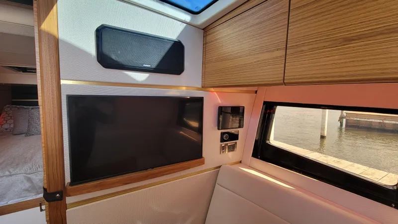 Slide: The Image of Interior of 2021 Boston Whaler 405 Conquest with TV, speaker, and window view. - 16