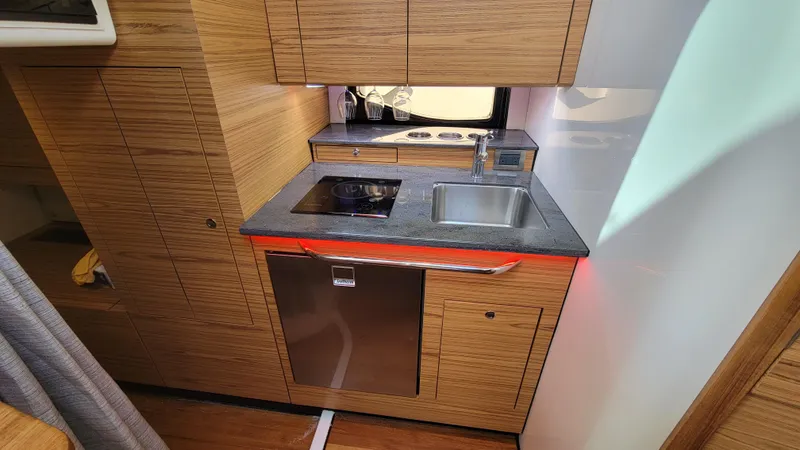 Slide: The Image of 2021 Boston Whaler 405 Conquest kitchen with modern appliances and wood cabinetry. - 17