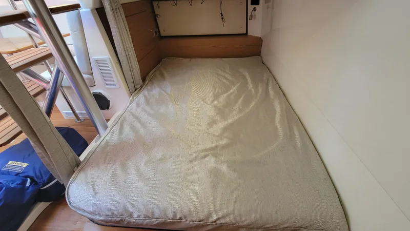 Slide: The Image of 2021 Boston Whaler 405 Conquest cabin with a cozy bed and wooden accents. - 18