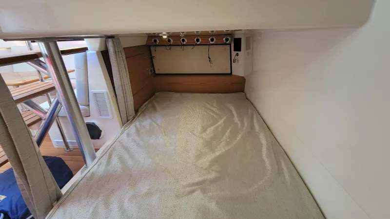 Slide: The Image of 2021 Boston Whaler 405 Conquest cabin interior with bed and fishing rod holders. - 19