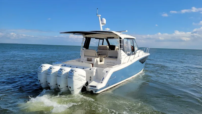 Slide: The Image of 2021 Boston Whaler 405 Conquest cruising on open water under a clear blue sky. - 4
