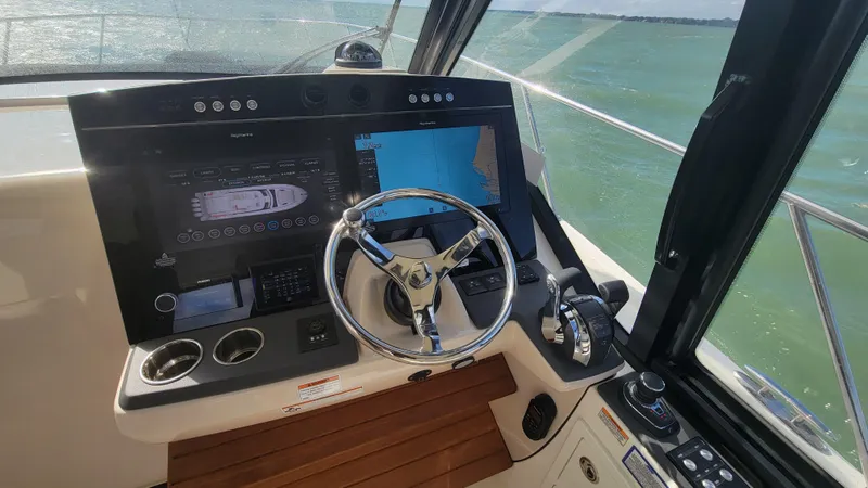 Slide: The Image of 2021 Boston Whaler 405 Conquest helm with advanced navigation displays and steering wheel. - 6