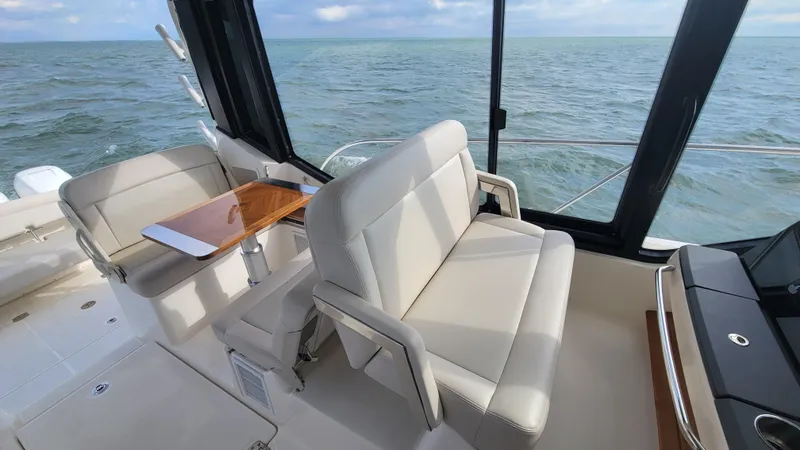Slide: The Image of 2021 Boston Whaler 405 Conquest interior with beige seating and ocean view. - 9