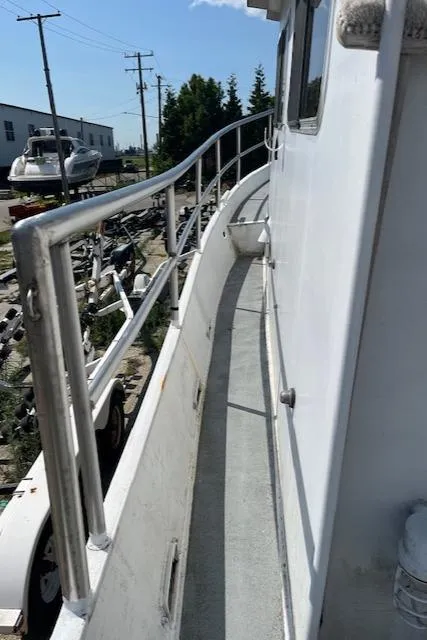 Slide: The Image of 1989 Maritime 340 Trawler side deck with railing, docked near other boats. - 2