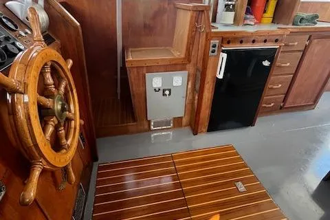Slide: The Image of 1989 Maritime 340 Trawler interior with wooden helm, compact kitchen, and storage. - 23
