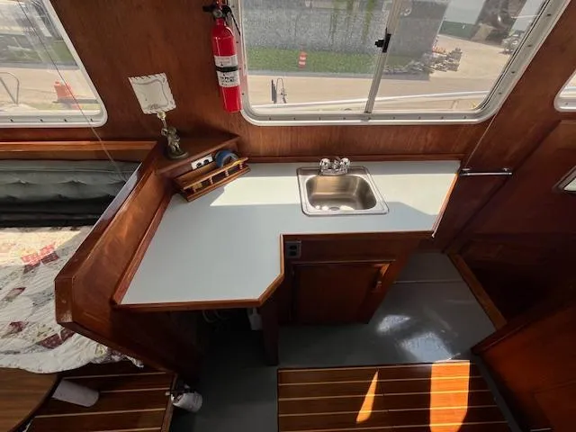 Slide: The Image of 1989 Maritime 340 Trawler interior with kitchenette, sink, and wooden cabinetry. - 26