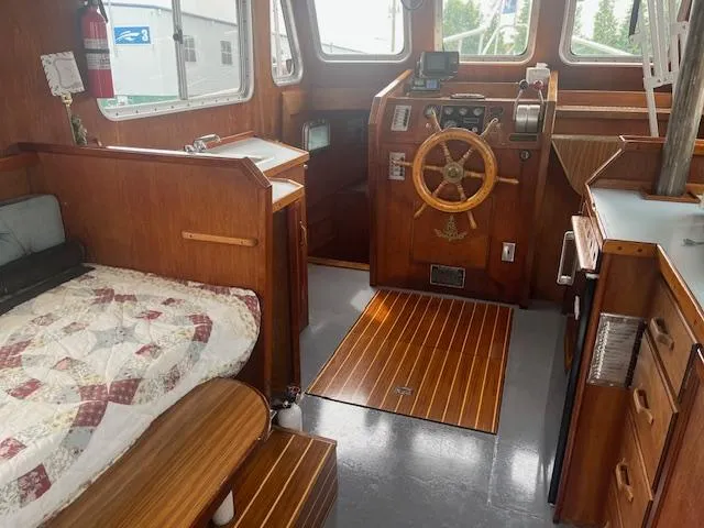 Slide: The Image of 1989 Maritime 340 Trawler interior with wooden helm, cozy bed, and nautical decor. - 27