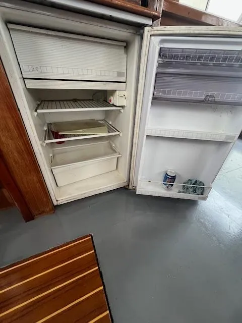 Slide: The Image of Open refrigerator inside 1989 Maritime 340 Trawler, showing shelves and door storage. - 30