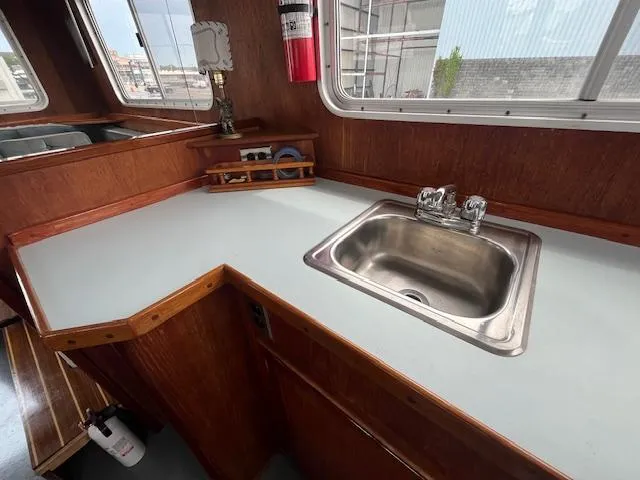 Slide: The Image of 1989 Maritime 340 Trawler kitchen with sink, wooden cabinetry, and window view. - 31