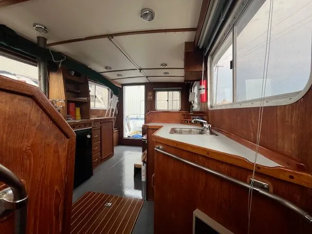 Slide: The Image of 1989 Maritime 340 Trawler interior with wooden cabinetry and kitchen area. - 33