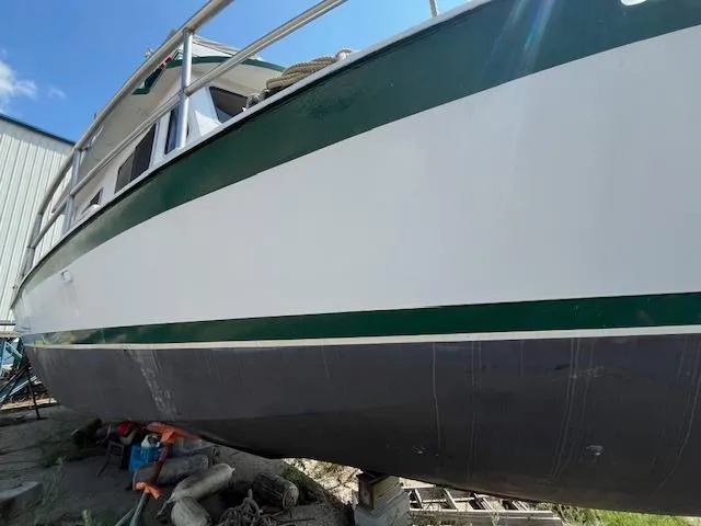 Slide: The Image of 1989 Maritime 340 Trawler boat on dry dock, green and white hull, side view. - 41