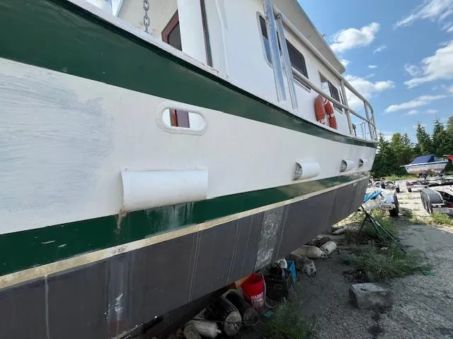 Slide: The Image of 1989 Maritime 340 Trawler on dry dock, showing hull and deck details under a clear sky. - 42