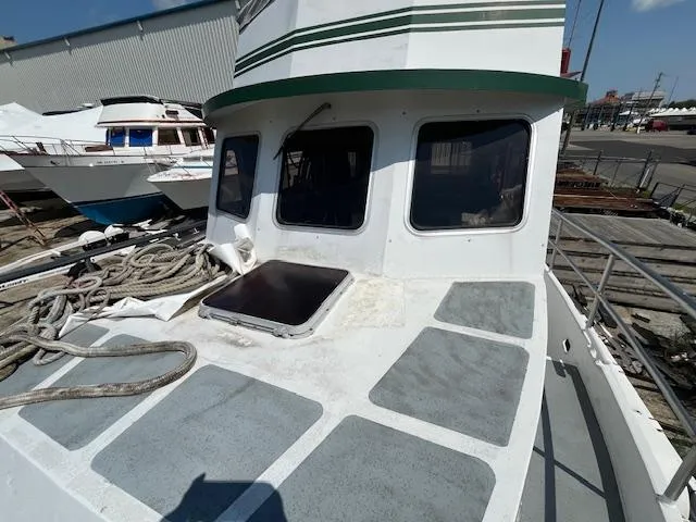 Slide: The Image of 1989 Maritime 340 Trawler docked, showing deck and cabin windows. - 8