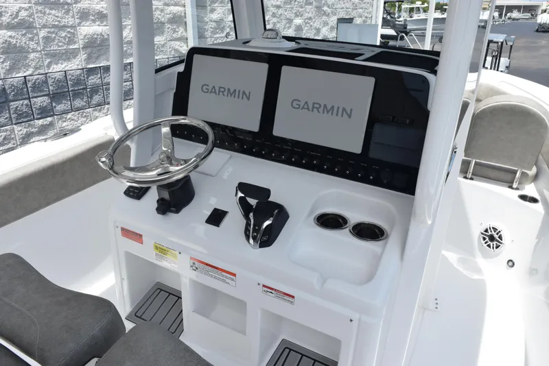 Slide: The Image of 2026 Sea Hunt Ultra 255 SE boat dashboard with dual Garmin displays and steering wheel. - 11