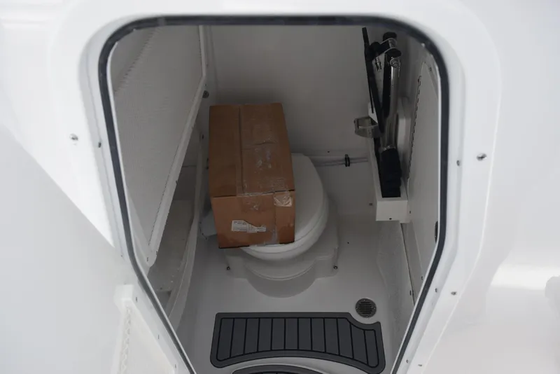 Slide: The Image of Interior of 2026 Sea Hunt Ultra 255 SE boat with a box on the toilet. - 21