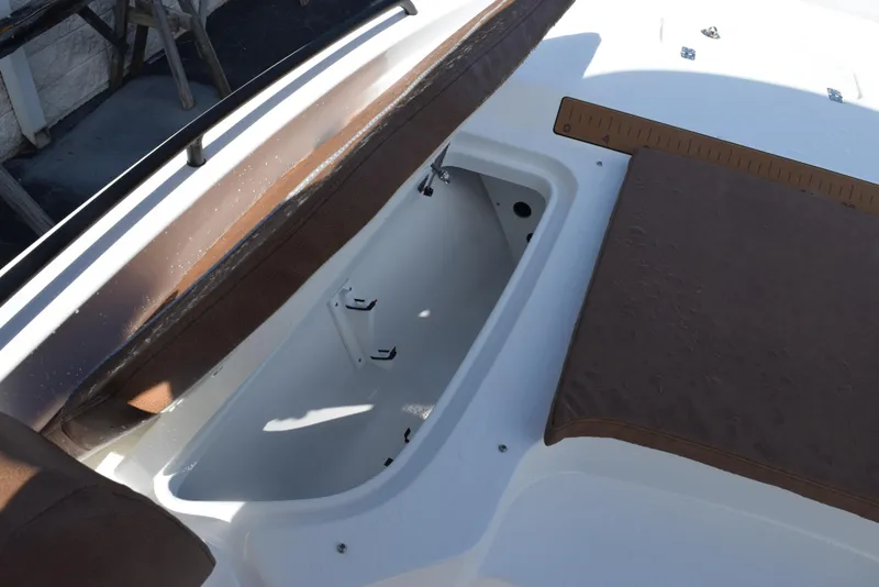 Slide: The Image of 2026 Sea Hunt BX 25 FS boat interior with storage compartment and brown seating. - 15