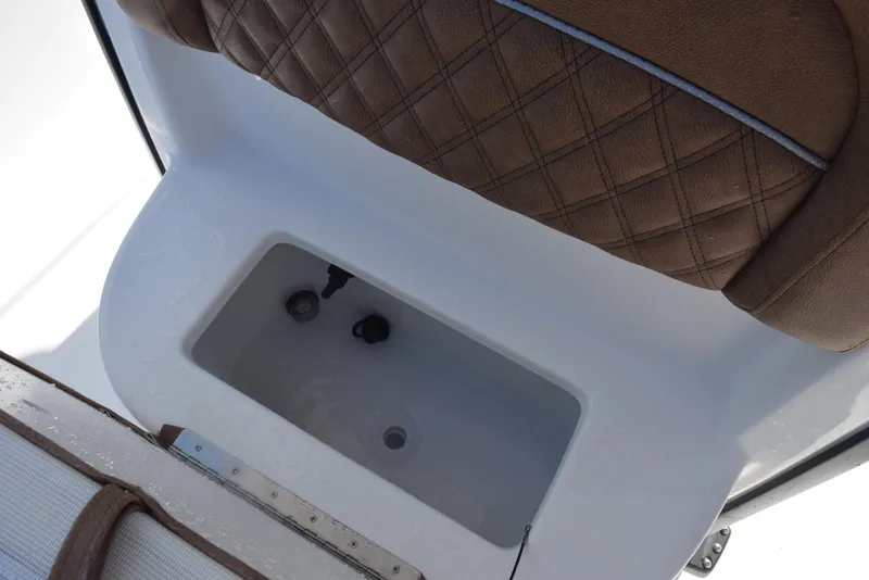 Slide: The Image of 2026 Sea Hunt BX 25 FS boat interior with brown cushioned seating and storage compartment. - 18