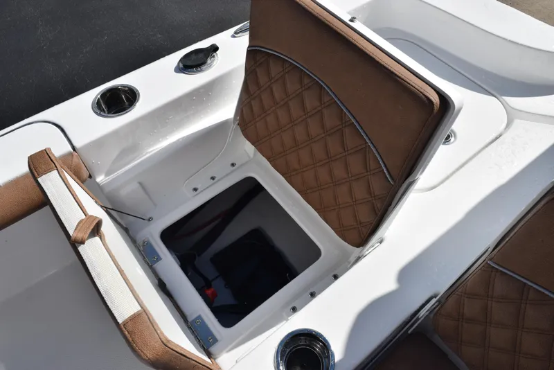 Slide: The Image of 2026 Sea Hunt BX 25 FS boat with open storage compartment and brown cushioned seating. - 23