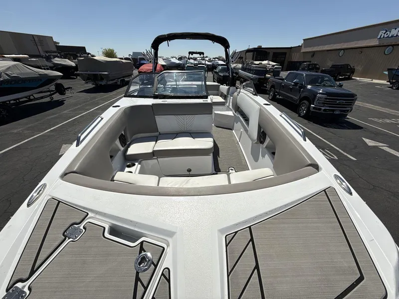 Slide: The Image of 2022 Glastron GTD 245 boat with spacious seating, parked in a marina lot. - 12
