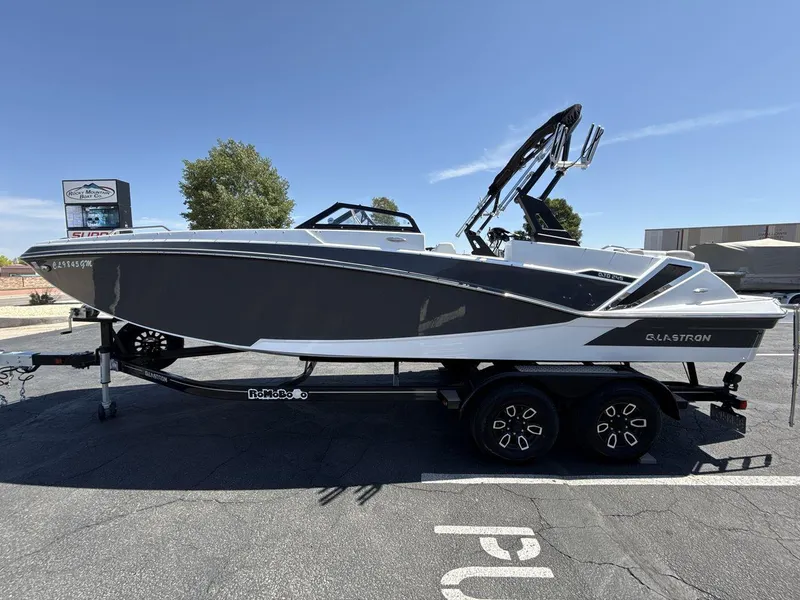 Slide: The Image of 2022 Glastron GTD 245 boat on trailer, parked outdoors under clear sky. - 2
