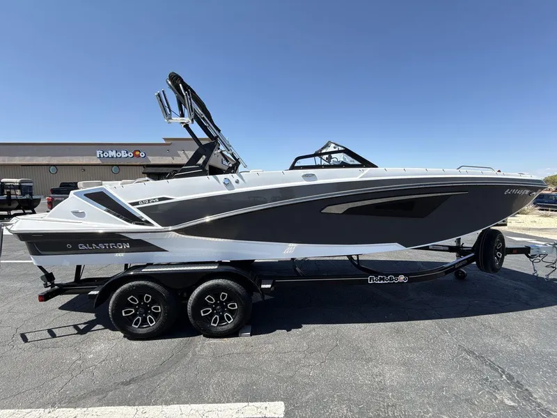 Slide: The Image of 2022 Glastron GTD 245 boat on trailer, parked outdoors under clear sky. - 6