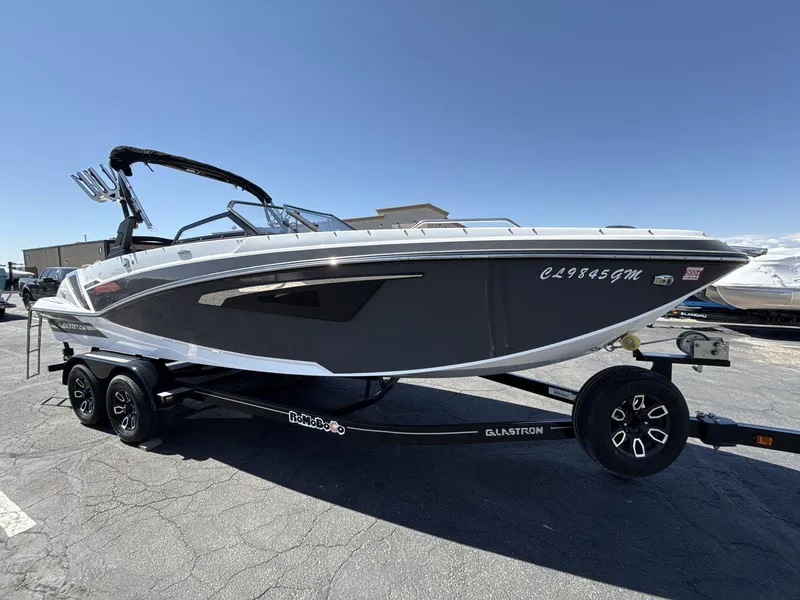 Slide: The Image of 2022 Glastron GTD 245 boat on trailer, sleek design, black and white exterior. - 7