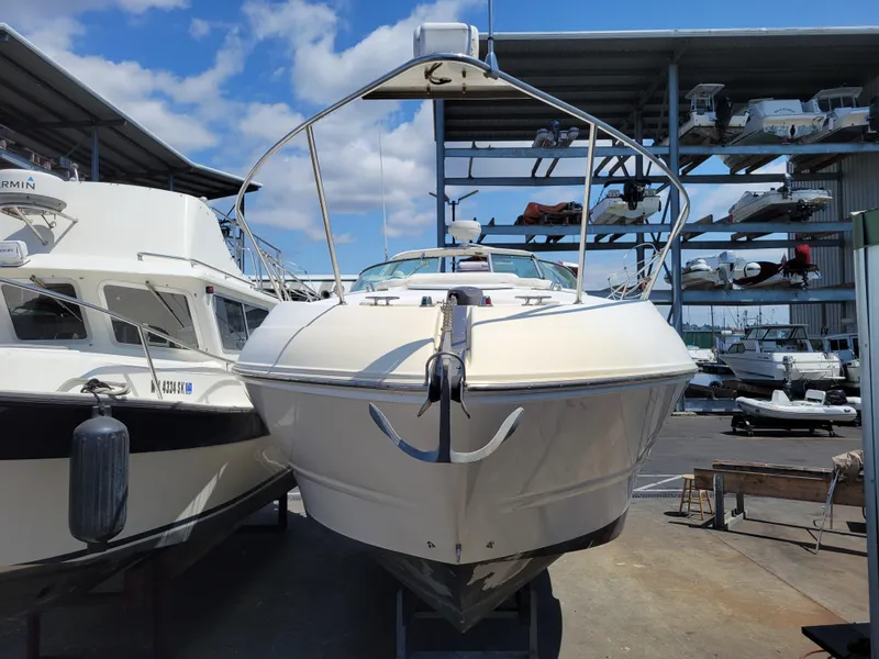 Slide: The Image of 2003 Larson 310 boat docked at marina, reflecting on calm water. - 2