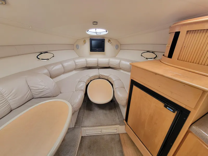 Slide: The Image of Interior of 2003 Larson 310 boat with plush seating and compact kitchenette. - 20