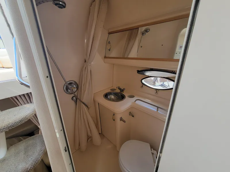 Slide: The Image of Bathroom interior of a 2003 Larson 310 boat with sink, toilet, and shower. - 22