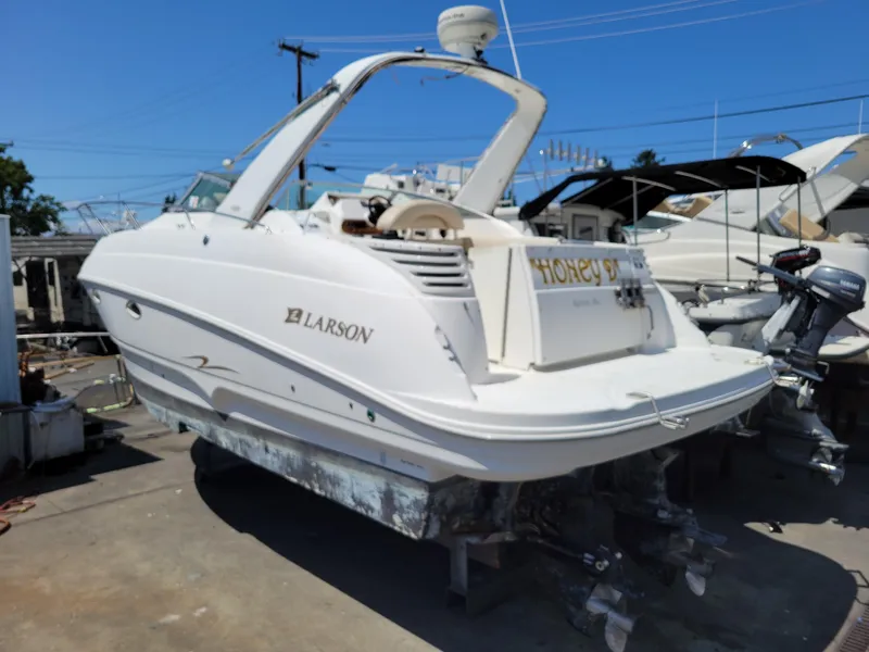 Slide: The Image of 2003 Larson 310 boat docked at marina under clear blue sky. - 3