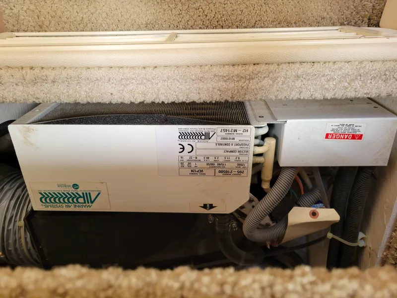 Slide: The Image of 2003 Larson 310 boat air conditioning unit with visible wiring and labels. - 31