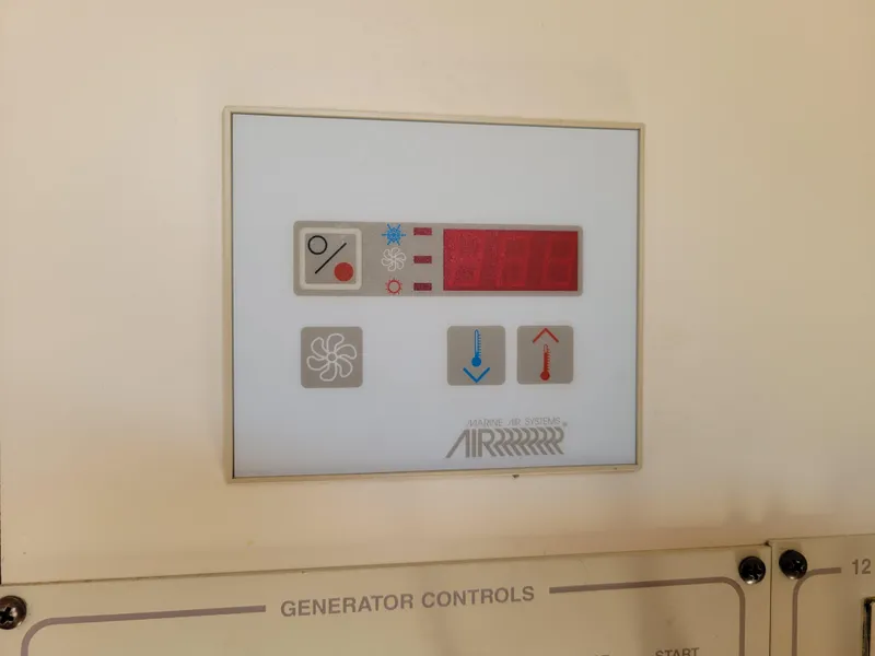 Slide: The Image of Control panel of a 2003 Larson 310 boat with generator controls. - 32