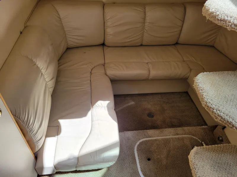 Slide: The Image of 2003 Larson 310 boat interior with beige leather seating and carpeted flooring. - 34