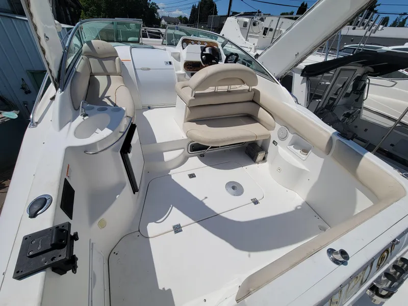 Slide: The Image of 2003 Larson 310 boat interior with seating and steering wheel, docked in a marina. - 5