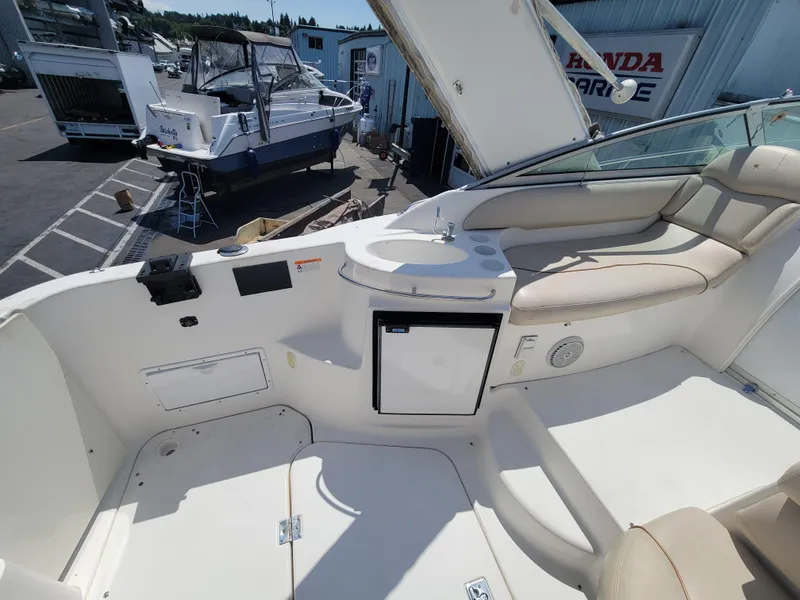 Slide: The Image of 2003 Larson 310 boat interior with seating and mini fridge. - 8