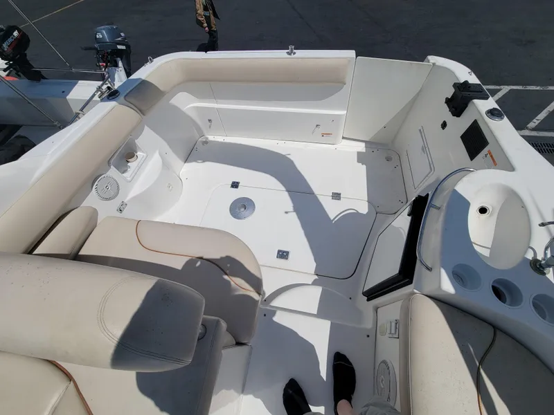 Slide: The Image of 2003 Larson 310 boat interior with beige seating and white deck. - 9