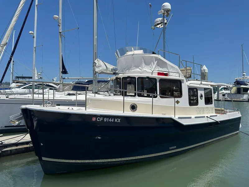 Slide: The Image of 2023 Ranger Tugs R-31 CB boat docked in marina, blue hull, clear sky background. - 0