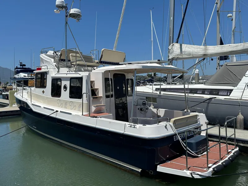 Slide: The Image of 2023 Ranger Tugs R-31 CB boat docked in marina under clear blue sky. - 1