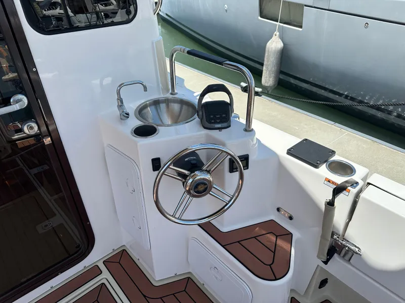 Slide: The Image of Cockpit of 2023 Ranger Tugs R-31 CB with steering wheel and sink. - 11