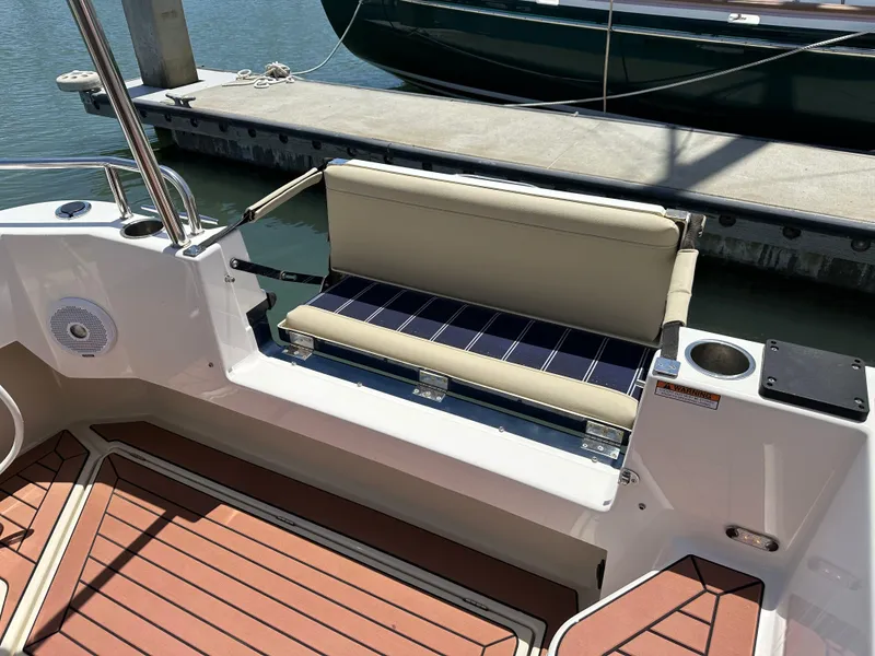Slide: The Image of 2023 Ranger Tugs R-31 CB boat with cushioned seating and teak-style flooring at the dock. - 18